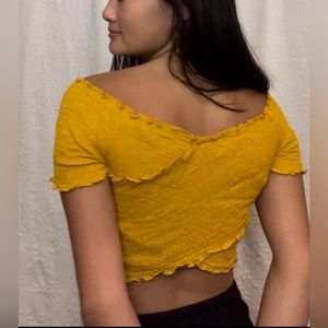 Something you’d find from American eagle. Cute yellow crop-top